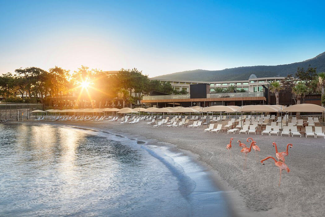Vogue Hotel Supreme Bodrum - widok na plażę o zachodzie słońca